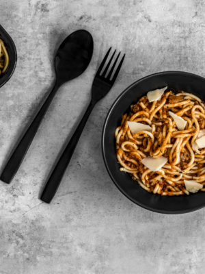 Des spaghettis à la viande appétissants, servis dans un plat, garnis de sauce à la viande riche, prêts à être mangés.