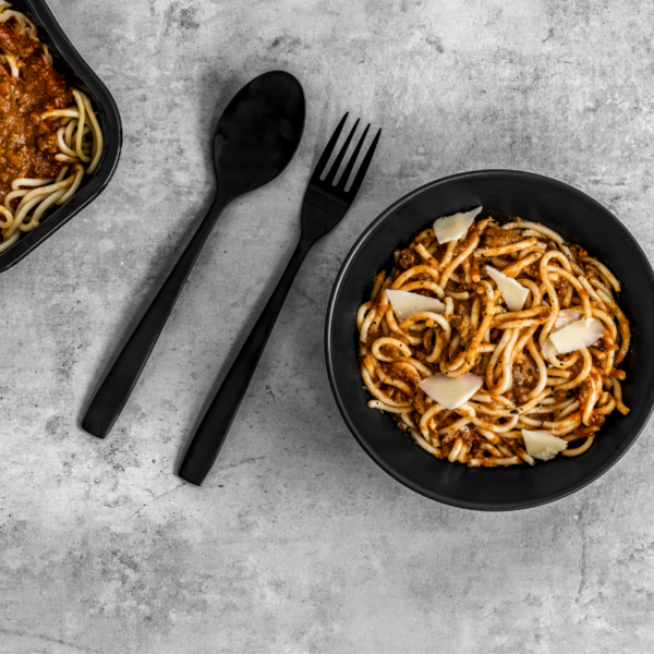 Des spaghettis à la viande appétissants, servis dans un plat, garnis de sauce à la viande riche, prêts à être mangés.