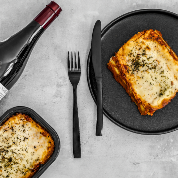 Manicottis farcis aux épinards et au fromage, joliment disposés dans une assiette de présentation, recouverts d'une sauce tomate maison et gratinés à la perfection. Un plat coloré et appétissant, prêt à être dégusté.